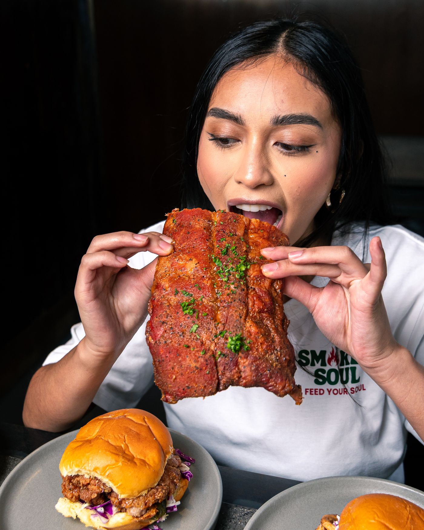 Diner biting into a rack of smoked ribs at Smokey Soul